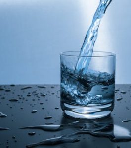 High-quality image of water being poured into a glass, illustrating hydration and purity.